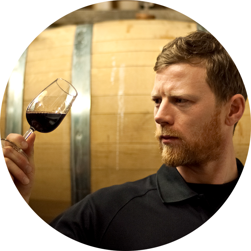 A winery worker checks a glass of wine